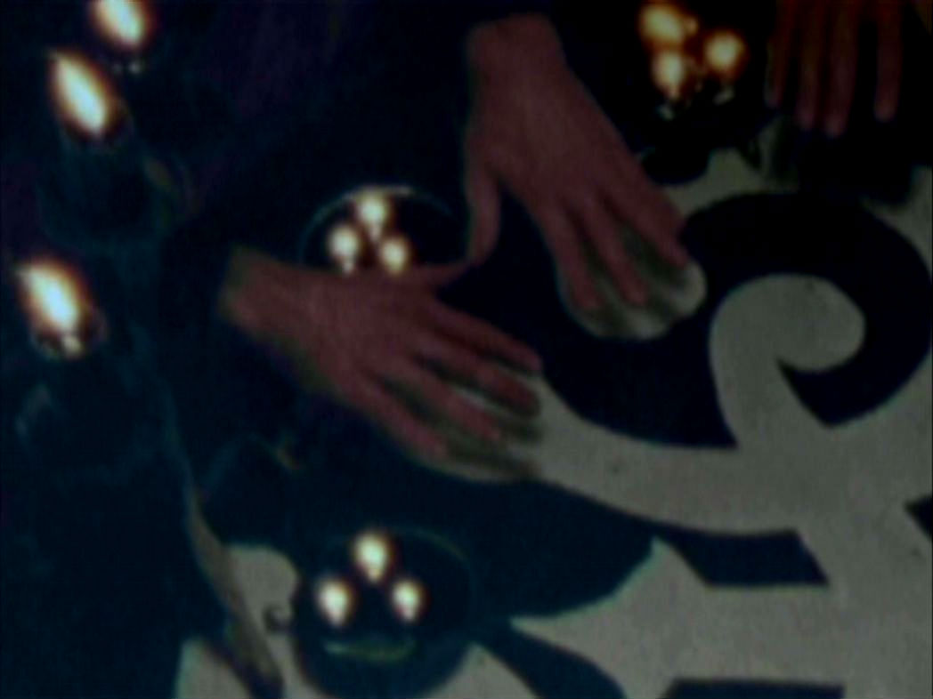 Hands stretch over an altar as the Eyghon spell is case.
